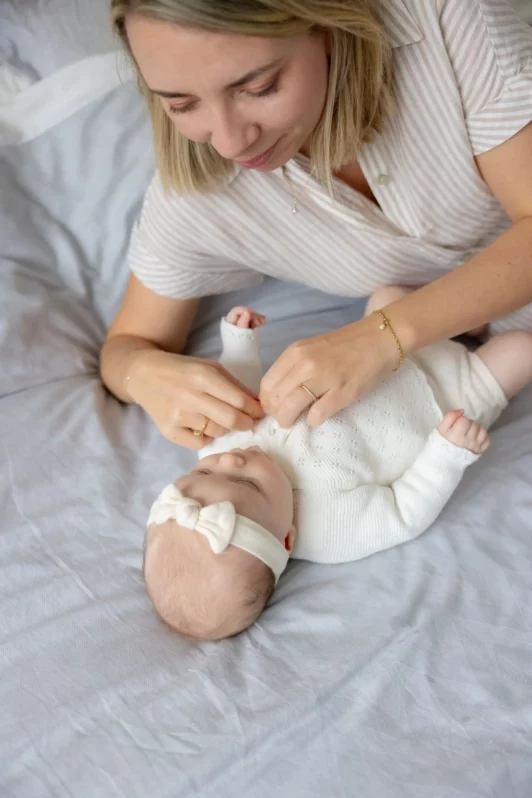 Moment de tendresse entre une mère et son bébé lors d’un shooting à domicile
