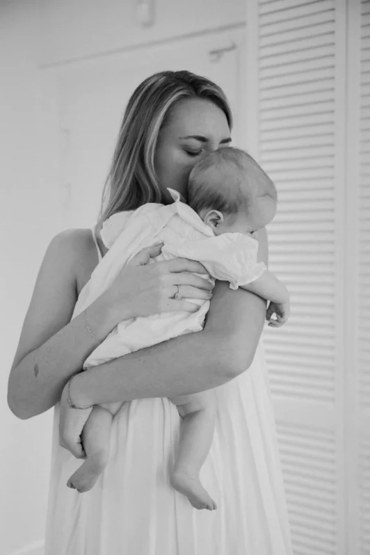 Moment de tendresse entre une mère et son bébé lors d’un shooting à domicile